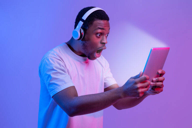 Portrait,Of,Amazed,Black,Guy,In,Wireless,Headphones,Looking,At