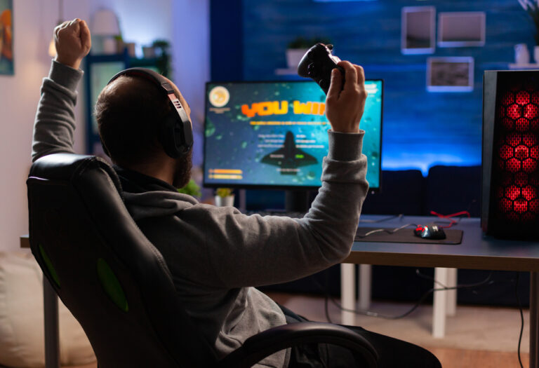 Winner,Gamer,Sitting,On,Gaming,Chair,At,Desk,And,Playing