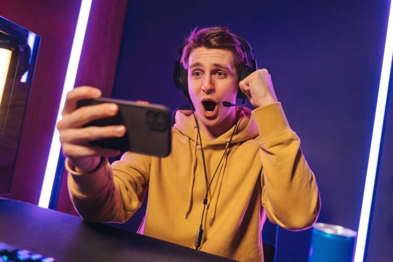 Excited,And,Shocked,Gamer,With,Headset,Playing,Video,Mobile,Game