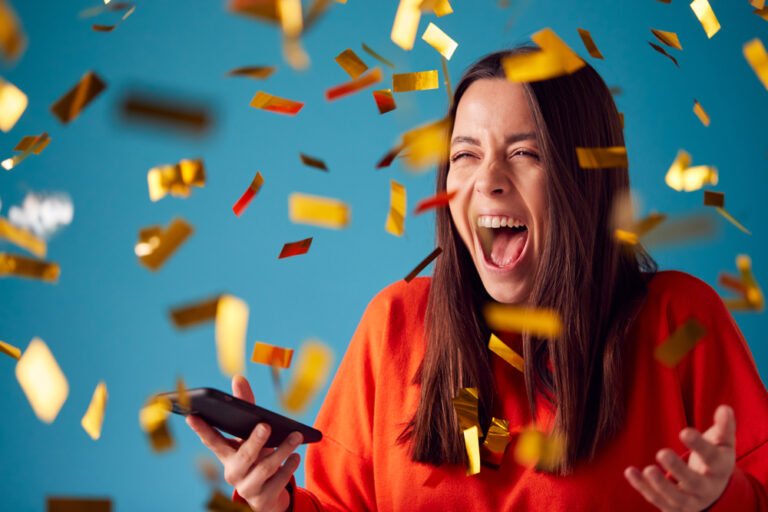 Celebrating,Young,Woman,With,Mobile,Phone,Winning,Prize,And,Showered