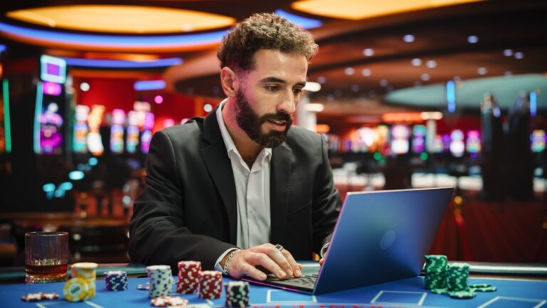 Portrait,Of,A,Young,Man,On,Casino,Floor,,Using,Laptop